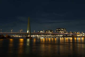 Fototapeta premium Severin Bridge in Germany, illuminated at night against the backdrop of a vibrant cityscape
