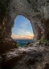 Vertical of sunset over a landscape seen from a cave