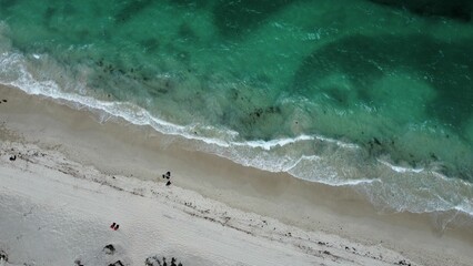 Aerial view of sandy beach with soft ocean waves