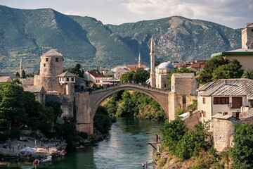 the village and bridge in mostar, bosnia has one bridge spanning a mountain range - obrazy, fototapety, plakaty