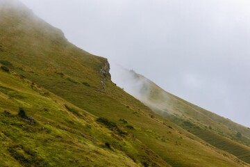 Peaceful scene of mountainous terrain featuring lush green grass and rocky outcrops in Georgia