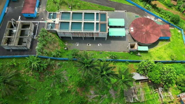 Descending and revealing a water treatment facility, at Sao tome, Africa - Drone shot
