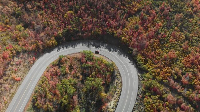 Top down subject of red car on Emigration Canyon road loop during fall Utah, USA.