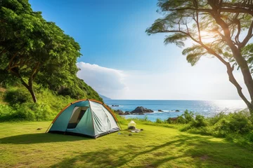 Fotobehang Camping tent and camping equipment on green grass with sea view background © Rudsaphon