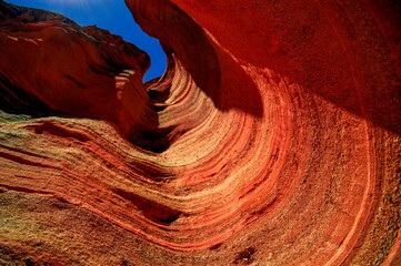 Low angle of a red-hued rock formation on a sunny day