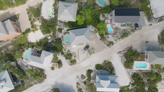 Eagle-eye aerial above condos on white sandy beach roads in Cape San Blas, Florida.