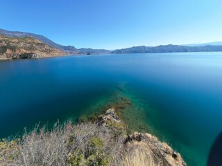 Scenic view of a blue lake nestled in a valley between the majestic mountains