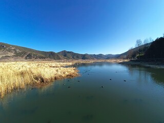 Scenic view of a blue lake nestled in a valley between the majestic mountains