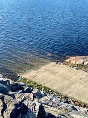 Fototapeta premium Winding stone pathway leads to a beachfront, with a serene body of water in the background