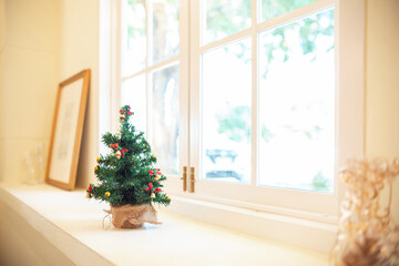 Decorate christmas event on counter by the bright window with small chrismas tree and wooden...