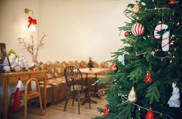 Decorate christmas event on christmas tree with small ball and toy. At the backgroud have wooden table and chair in living room for relax