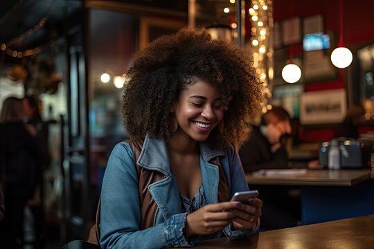A young African woman looks at her smartphone and smiles in a cafe. The concept of the joy of communication. Generated by AI.