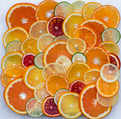 A group of sliced oranges and limes in a plate