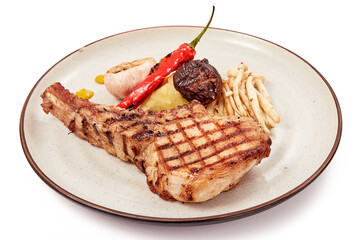 Pork chop steak (tomahawk) served with shimeji mushrooms, shiitake mushrooms, garlic and grilled chilies, mustard and mashed potatoes isolated on white background.