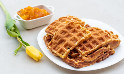 A delicious plate of waffles on a table decorated with flowers