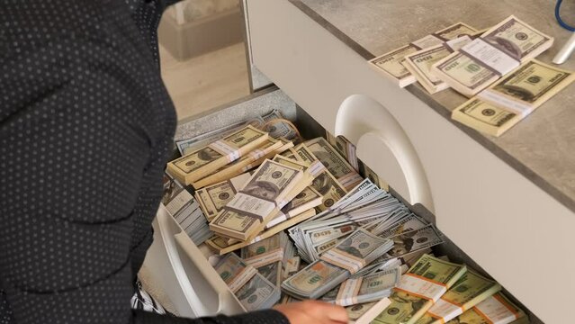 Man quickly puts the money he received or stolen into a drawer of a cabinet, loot, evading taxes, money laundering. Fast motion. Cash savings.