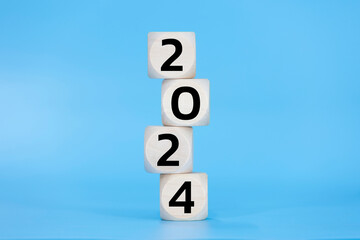 Wooden dice 2024 happy new year on blue background pastel black number