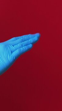 Vertical video. Quarantine hygiene. Pandemic present. Man rejecting gift box from female bare hand accepting in protective gloves coronavirus safety risk isolated on red background.