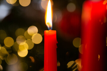 Christmas candles.Burning candles on bokeh background.Christmas festive background with red burning...