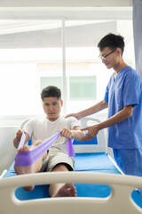 Doctor examining male patient's injured arm, stretching and exercising Doing pain therapy, physical therapist working with patient in closed clinic