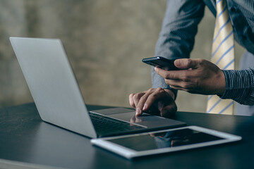 Young Asian businessman working with laptop, checking graphs, company budget reports, production control. Operational inspection cost plus price Close-up pictures