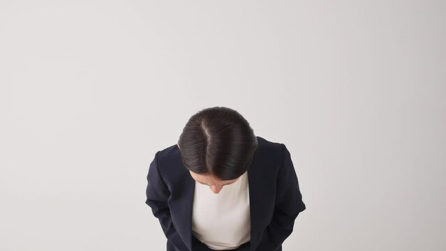 お辞儀して謝罪するビジネスウーマン　白背景