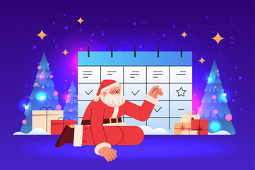 santa claus in red costume near holiday planner christmas organizer happy new year merry christmas holidays celebration concept