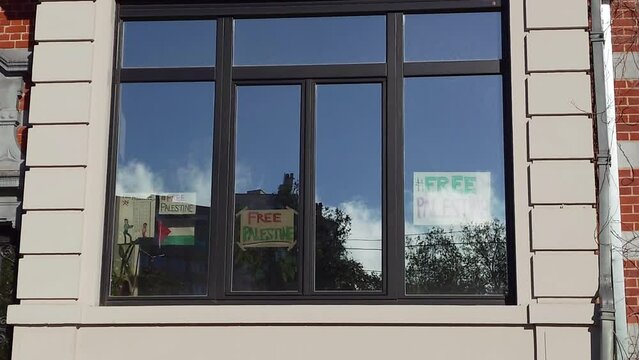 Free Palestine Slogans on Window of House against Hopeful Blue Cloudy Sky - Brussels, Belgium