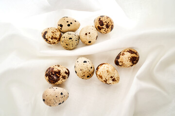 Quail eggs on a white linen towel close-up.
