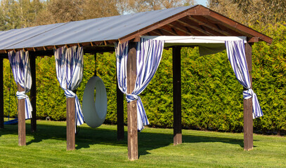 Gazebo on a green lawn in the park