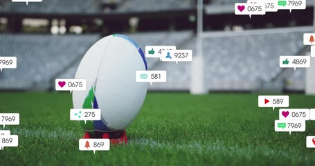 Animation of social media icons foating against close up of a rugby ball on a stand in the stadium