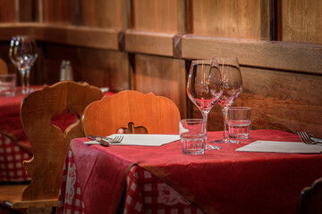 Tables with a checkered tablecloth at an Alsatian winstub restaurant in a traditional half timbered...