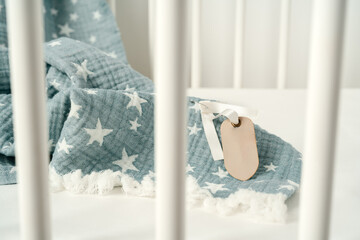 Soft blue muslin blanket hanging on a baby's bed