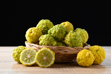 Kaffir lime fruit in basket with black background, Organic ingredients in Thai cuisne, beauty and cosmetics