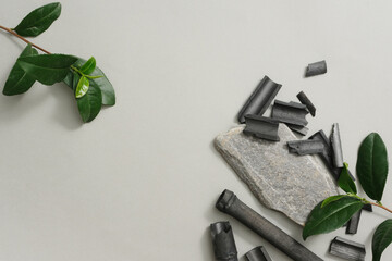 Green tea leaves and bamboo charcoal on gray background. Blank space for design and product...