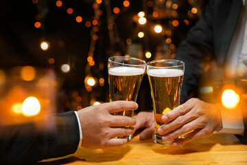 food and drink male friends are happy drinking beer and clinking glasses at a bar or pub.