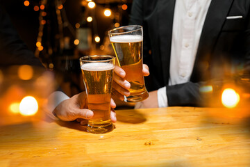 food and drink male friends are happy drinking beer and clinking glasses at a bar or pub.