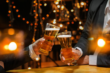 food and drink male friends are happy drinking beer and clinking glasses at a bar or pub.