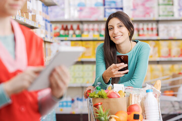 Young woman using a smartphone at the supermarket
