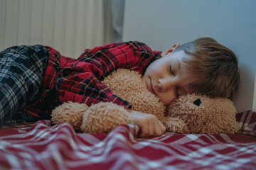 e boy falling asleep by heater hugging teddy bear waiting for santa