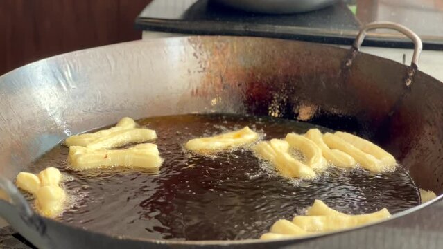 4K deep-fried dough stick or patongko being fried in a pan with boiling oil, Thailand street food breakfast favorite among tourists