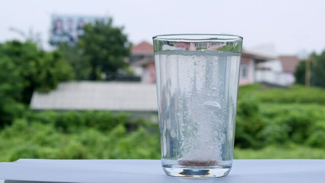 Dropping a tablet of antacid into a glass of water that burst into tiny bubbles in the water
