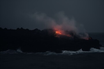 Dramatic interaction of lava flowing into the ocean, emitting a fiery hue.