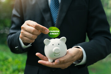 Carbon credit concept with businessman holding leaf green globe reducing saving carbon emissions...