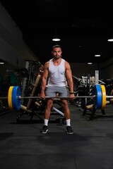 Strong Hispanic man deadlift at a gym.