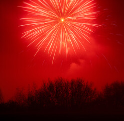 Red firework over trees long exposure
