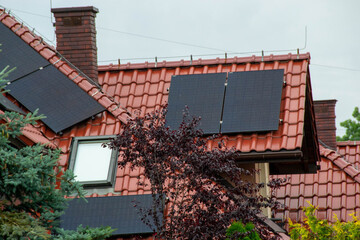 Historic farm house with modern solar panels on roof and wall