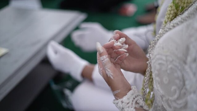 Indonesian sundanese traditional wedding. The hands of the bride and groom praying after carrying out the marriage contract at the wedding party wearing traditional Sundanese bridal attire