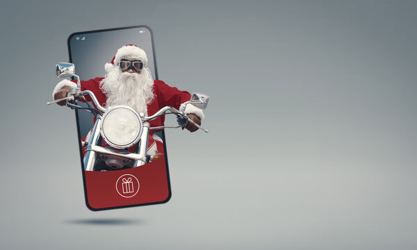 Santa Claus riding a motorcycle and coming out of a smartphone screen