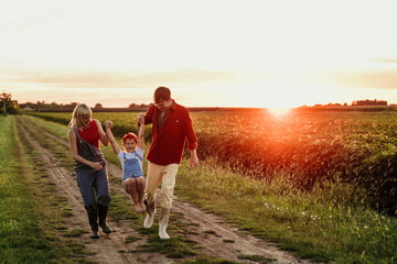 A joyful daughter runs to her beaming parents amidst the stunning countryside sunset, a perfect end...